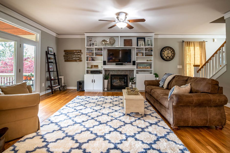 Spacious living room featuring a ceiling fan, large sofa, and elegant decor for a modern yet cozy feel.