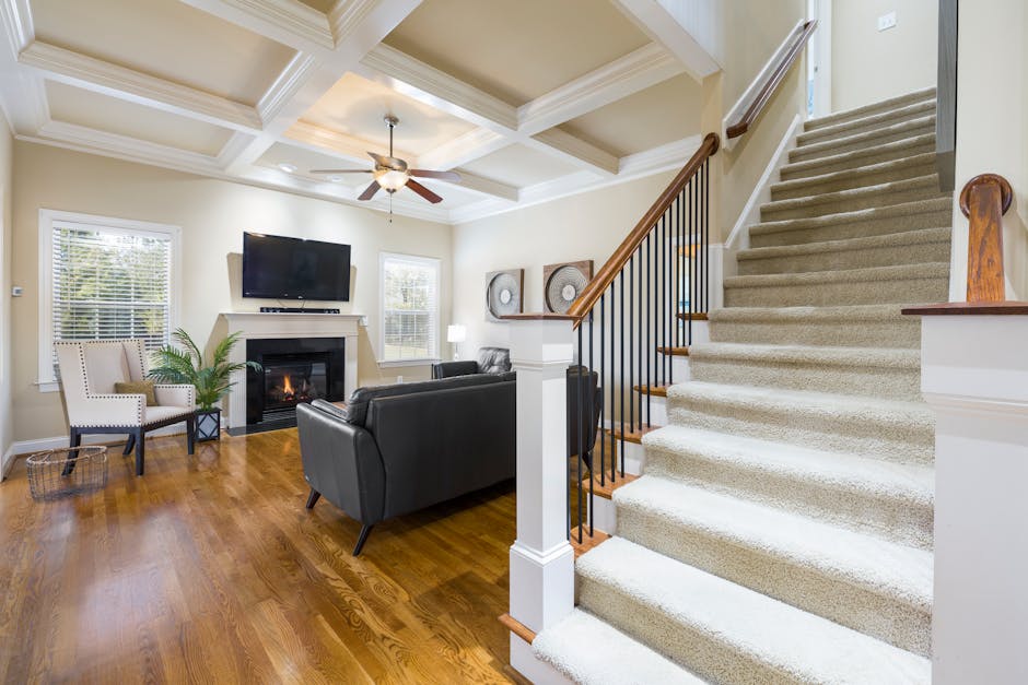 Elegant living room with fireplace, TV, and staircase. Cozy and inviting interior.