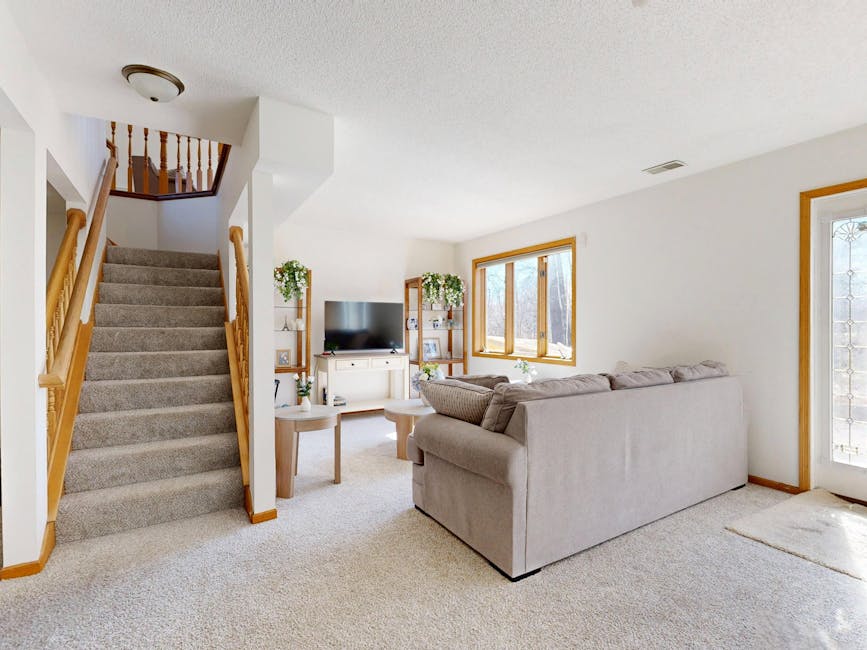 Inviting living room with cozy sofa and natural light through large windows.